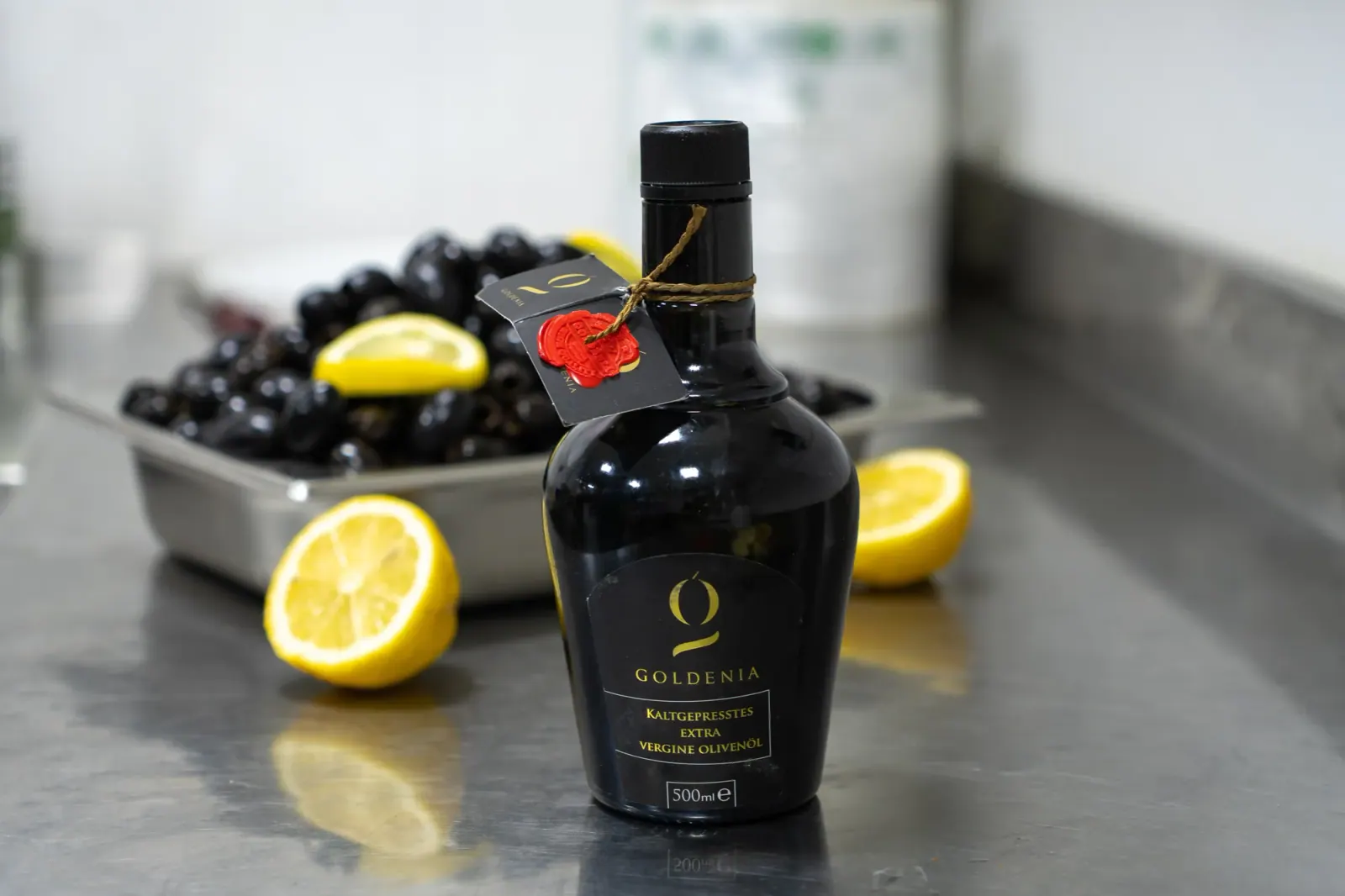 Olivenöl-Flasche mit Oliven und Zitronen als Produktaufnahme
